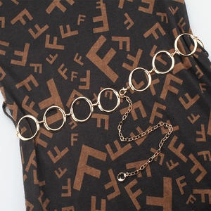 Detail of gold circular link chain belt with adjustable extender on textured fabric