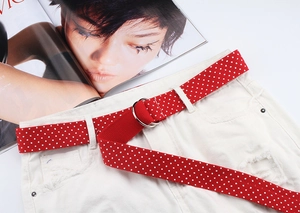 Detail of red nylon canvas belt with white polka dots and silver double D-ring buckle