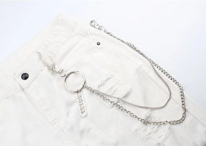 Detail of silver double-layered metal trousers chain with hollow star and SOLA charm