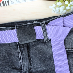 Light purple nylon canvas belt for women with black plastic buckle on dark grey jeans