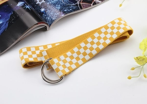 Détail de la ceinture en nylon jaune à damier avec boucle métallique à double anneau D