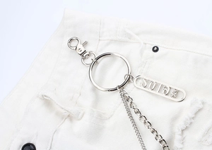 Close-up of double-layered silver metal pants chain with SOIE tag on denim