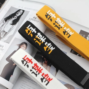 Unisex canvas belt with embroidered text and metal buckle in yellow, black, and white colors