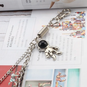 Detail of silver double-layered metal trousers chain with astronaut charm and carabiner