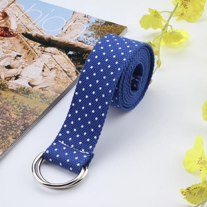 Detail of navy blue canvas belt with white polka dots and dual metal D-ring buckle
