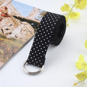 Detailed view of black nylon belt with white polka dots and silver double D-ring buckle