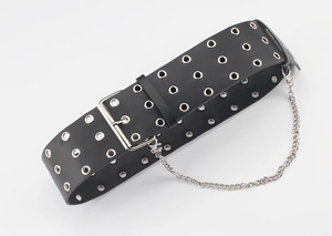 Detail view of punk wide black belt featuring triple-row silver eyelets and metal chain