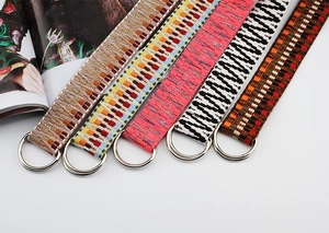 Detail of woven nylon belts with assorted ethnic patterns and silver double ring buckles