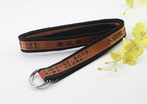 Detail of canvas belt with silver D-ring buckle and Chinese calligraphy embroidery