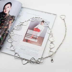 Detailed macro view of heart-shaped hollow metal link chain belt with adjustable lobster clasp