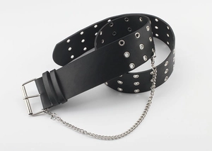 Detail of black punk waist belt with double eyelet holes and silver metal chain accessory