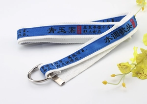 Detail of white nylon belt featuring blue calligraphy ribbon and silver D-ring buckle