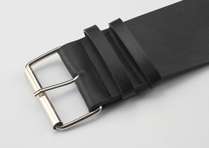 Close-up of black leather punk belt showing the silver metal buckle and stitching detail