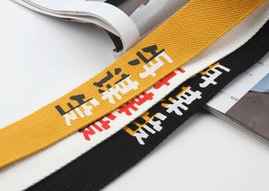 Macro view of thickened canvas belts in yellow, white, and black with printed text