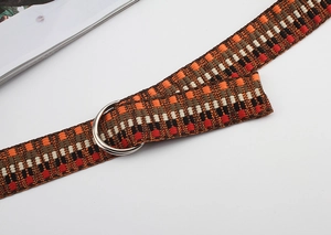 Detail of colorful geometric woven nylon belt featuring a silver double D-ring buckle