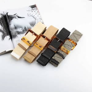 Close-up of four woven elastic belts with vintage resin buckles in various neutral colors