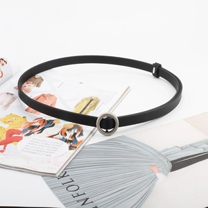 Elegant minimalist black thin waist belt with silver round buckle on fashion magazine