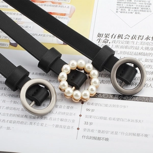 Close-up of elegant black belts with pearl encrusted and matte silver circular buckles