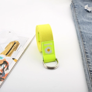 Détail de la ceinture en toile vert fluo avec broderie marguerite et boucle double D