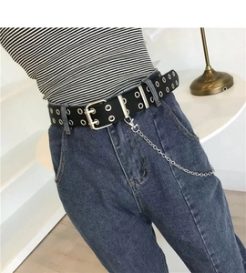 Detail of a black punk leather belt with double grommets and detachable silver metal chain