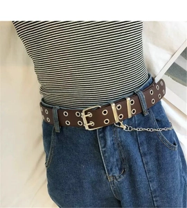 Detail of dark brown double grommet leather belt with detachable silver metal chain on jeans