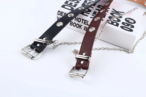 Detail of punk style leather belts with silver metal eyelets and decorative chains