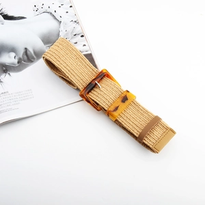 Detail view of woven straw belt featuring a vintage amber resin square buckle and leather tip