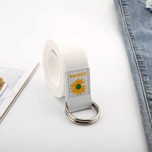 Détail d'une ceinture en toile blanche avec broderie tournesol, écusson et doubles boucles en D