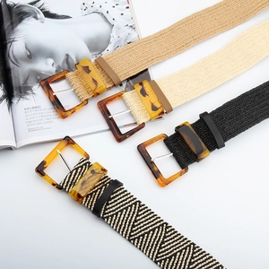 Close-up of four woven elastic belts with vintage amber style buckles in multiple colors