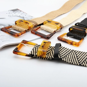 Detail of elastic braided belts with retro resin buckles in beige, black and brown