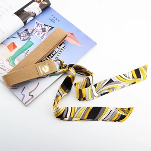 Détail de la ceinture en toile avec foulard en soie imprimé et patch en cuir marguerite