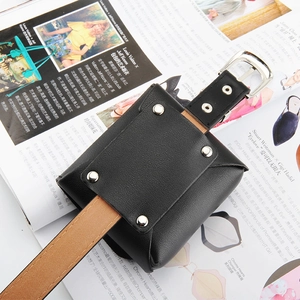 Détail d'un mini sac de taille noir avec clous et une ceinture classique en cuir marron