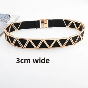 Détail d'une ceinture élastique noire de 3 cm avec une boucle triangulaire dorée