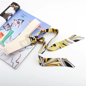 Détail de ceinture en toile avec imprimé marguerite, garniture cuir et foulard en soie