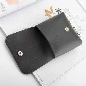 Vue macro détaillée de la pochette en cuir noir avec bouton-pression en argent et coutures fines