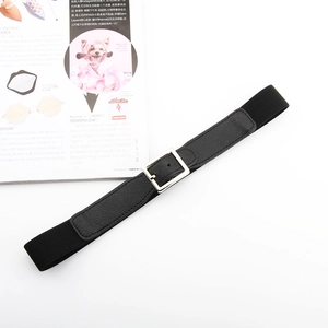 Détail de la ceinture tressée noire élastique avec boucle en métal argenté sur fond blanc