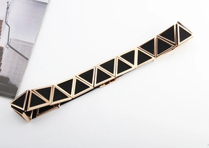 Détail d'une ceinture élastique noire moderne avec boucle triangulaire dorée