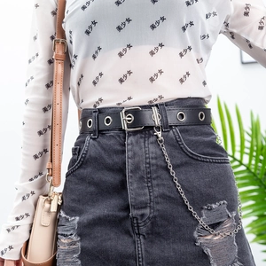 Detail of a punk PU leather belt with silver eyelets and a multi-ring metal chain