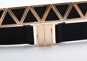 Gros plan sur la ceinture élastique noire avec boucle métallique dorée en forme de triangle
