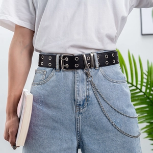 Detail of punk black PU leather belt with silver double eyelets and metal chains on jeans