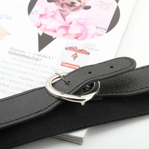 Détail macro de la ceinture tressée élastique avec boucle argentée et embout en cuir