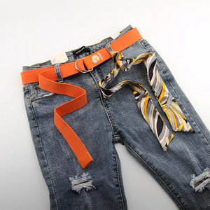 Jean bleu délavé avec ceinture en toile orange marguerite et foulard décoratif en soie