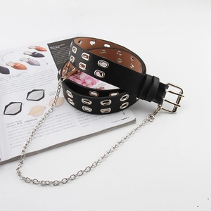 Détail d'une ceinture punk en cuir noir à double œillets avec chaîne argentée