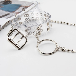 Dettaglio cintura trasparente in PVC con doppi occhielli e catena in metallo argento