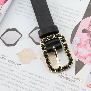 Close-up of black litchi leather thin belt with elegant gold chain rectangular buckle