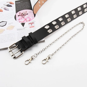 Détail de la ceinture punk en cuir noir avec doubles oeillets et chaîne argentée amovible