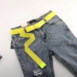 Détail d'une ceinture en toile jaune fluo avec motif marguerite et double boucle D