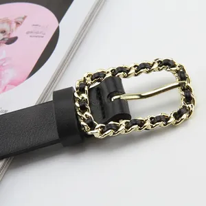 Detail of elegant gold chain interwoven with black leather on the rectangular belt buckle
