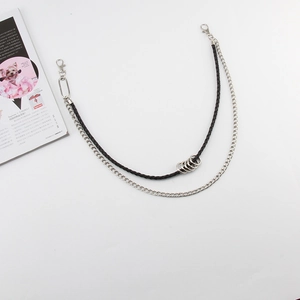 Detail of double-layer trouser chain with black braided leather and silver metal links