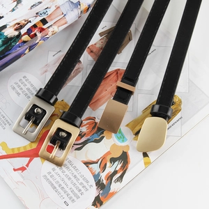 Detail of four black leather belts with various vintage and minimalist metal buckles